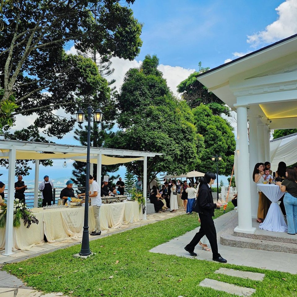 Guests under the white garden pavilion at Hillside Kokol with the sea horizon behind