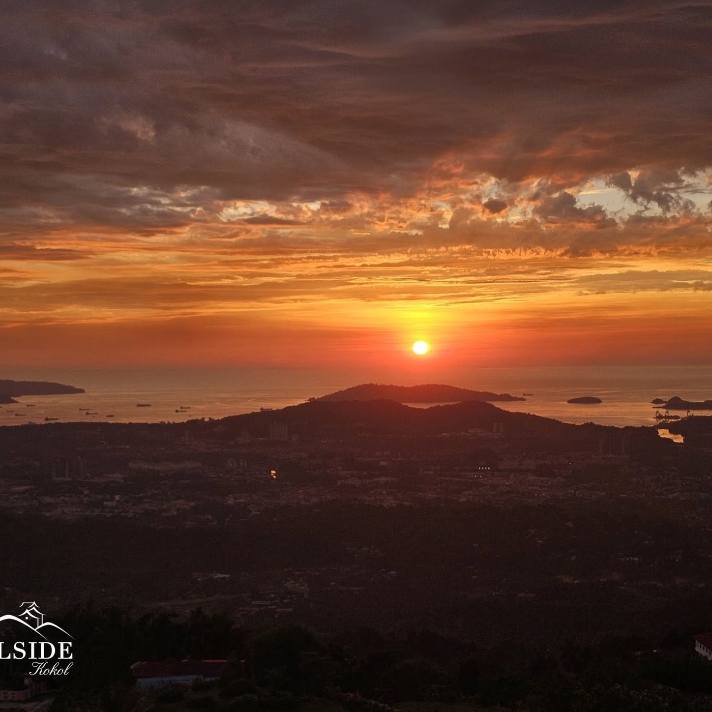 The sun setting into the South China Sea beyond Kota Kinabalu, with islands and cargo ships on the horizon, photographed from Hillside Kokol